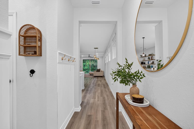 Entry hallway with wood floors and round mirror at 93 Lochloosa Ct, St. Johns, FL 32259