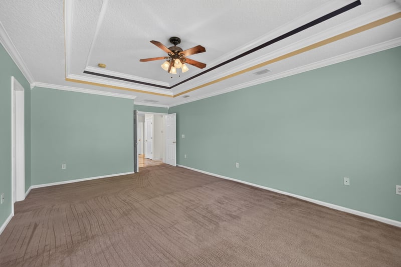 Empty room with tray ceiling and green walls at 2282 Justin Lake Dr, Jacksonville, FL