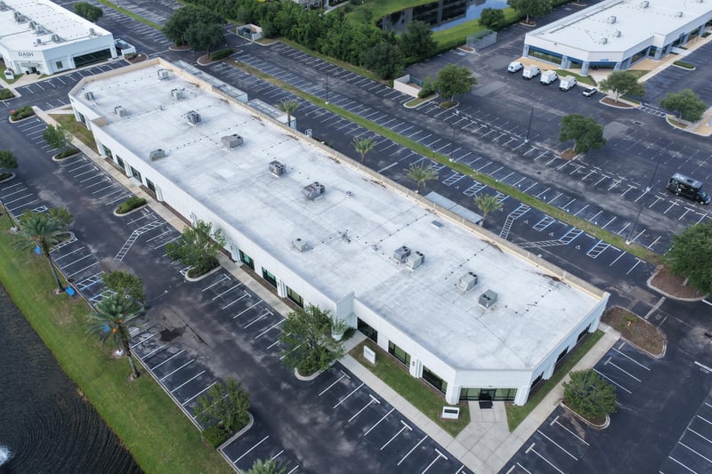 Aerial view of a building roof with pond and parking at 10550 Deerwood Park Blvd, Jacksonville, FL 32256