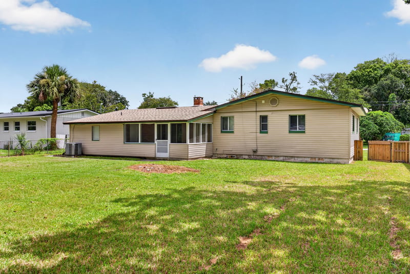 Rear exterior showing the backyard lawn at 2618 Arlex Dr E, Jacksonville, FL