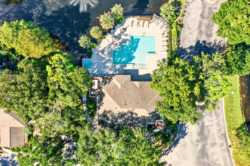 Aerial view of pool and condo buildings among trees in Jacksonville, FL