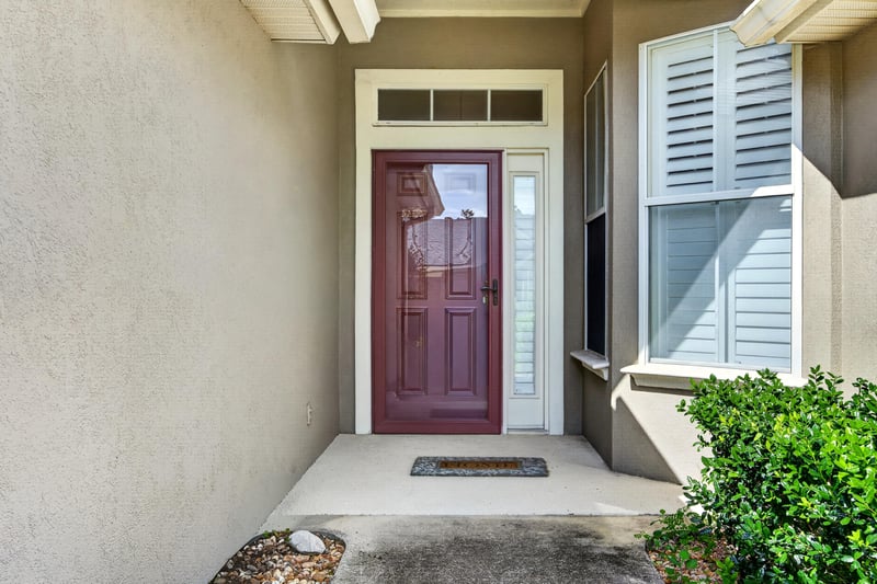 Front door with red paint and sidelight window at 2131 E Stone Creek Dr, Fleming Island, FL
