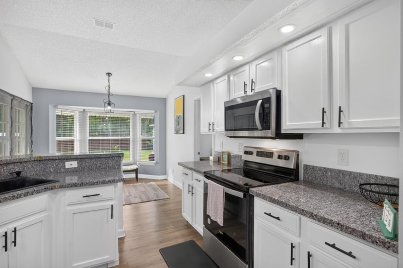Kitchen with microwave and granite counters at 8921 Needlepoint Pl, Jacksonville, FL 32244
