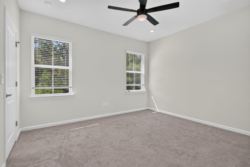 Carpeted bedroom with ceiling fan and two windows at 39 Mellowood Ln, St. Augustine, FL 32092