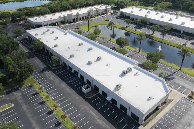 Aerial view of a building roof with pond and parking lot at 10550 Deerwood Park Blvd, Jacksonville, FL 32256