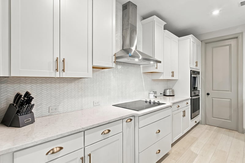 Kitchen cabinetry with range hood and tile backsplash at 3921 Spyglass Hill Ln