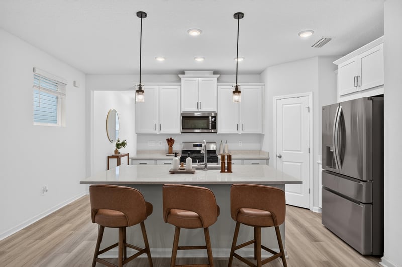 Kitchen island with bar stools and pendant lighting at 93 Lochloosa Ct, St. Johns, FL 32259