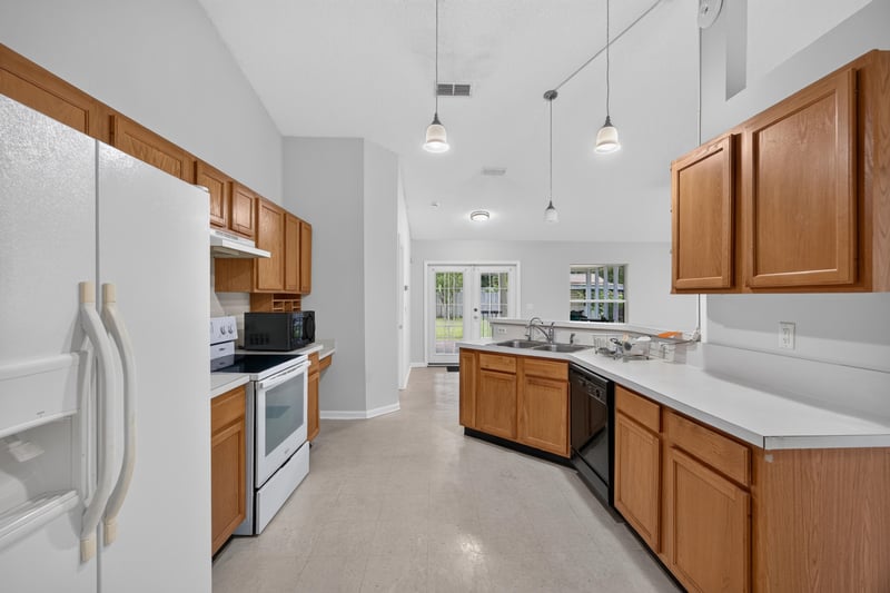 Kitchen with oak cabinets and refrigerator at 9691 Nelson Forks Dr, Jacksonville, FL 32222
