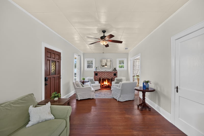 Living room with brick fireplace and ceiling fan at 101 N Lake St, Crescent City, FL