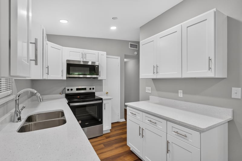 Kitchen sink and stove with white cabinets at 1928 Montmarte Dr, Jacksonville, FL 32210