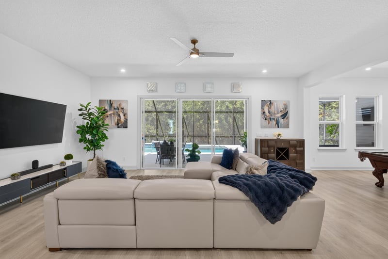 Living room with sectional sofa and wall-mounted TV at 785 Back Creek Dr, St. Augustine, FL 32092