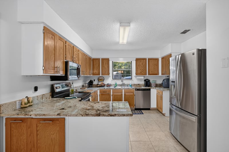 Kitchen with white cabinets and stainless refrigerator at 2435 Range Line Rd, Middleburg, FL