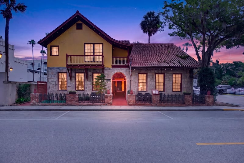 Day-to-dusk view of the building facade and lit windows at 115 Cordova St, St. Augustine, FL