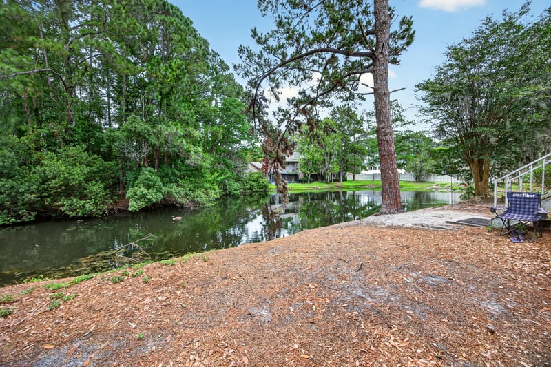 Pond view with trees near the condo in Jacksonville, FL