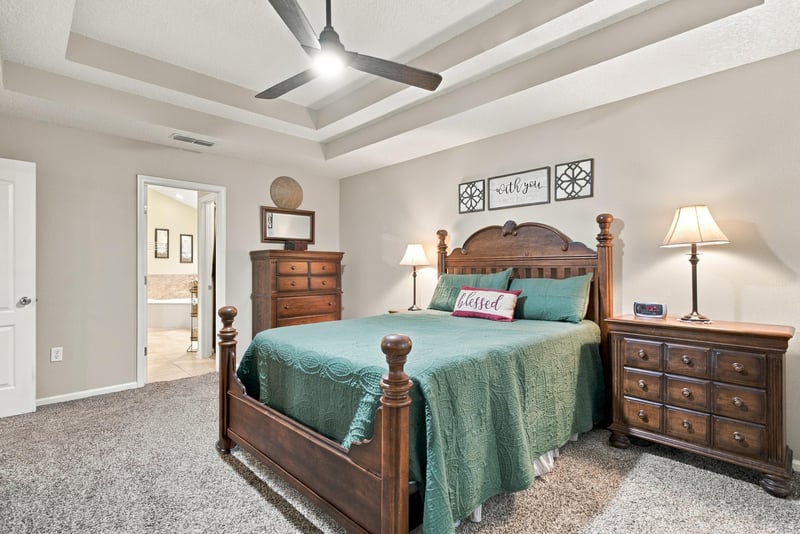 Primary bedroom with tray ceiling and dresser at 10923 Black Diamond Ct, Jacksonville, FL