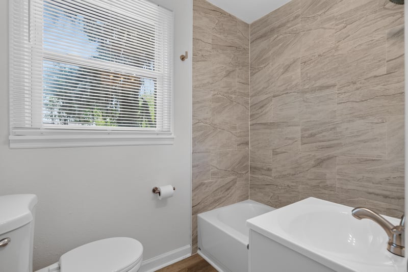 Bathroom with tiled tub and window at 855 Cornwallis Dr, Jacksonville, FL