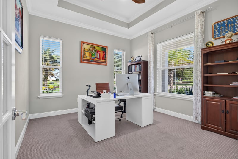 Home office with desk and built-in shelving at 22 Azura Point