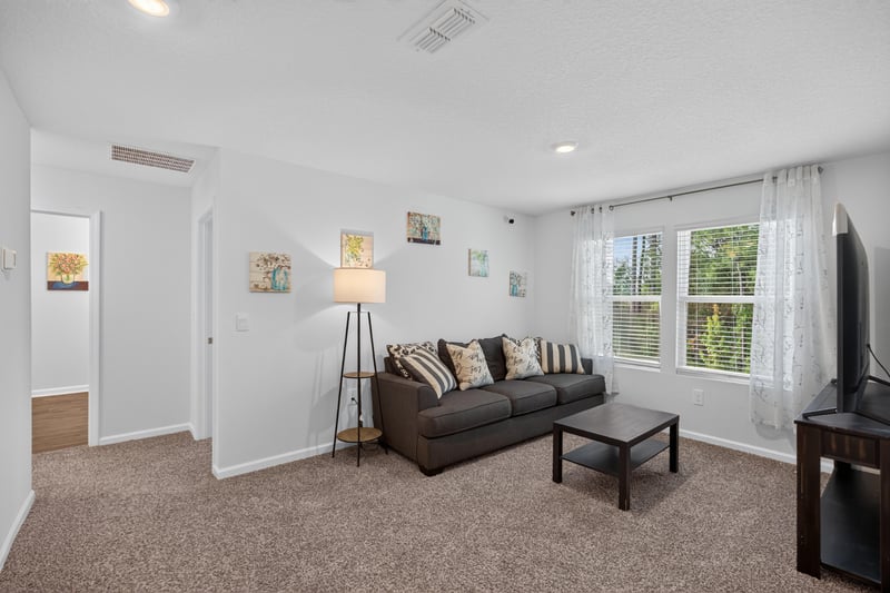 Upstairs bonus room with sofa and TV at 65255 Frst Glen Ln, Yulee, FL 32097