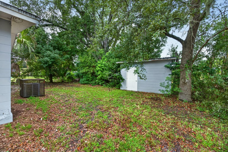 Backyard with open grass, trees and shed at 4030 Leonard Cir W, Jacksonville, FL 32209