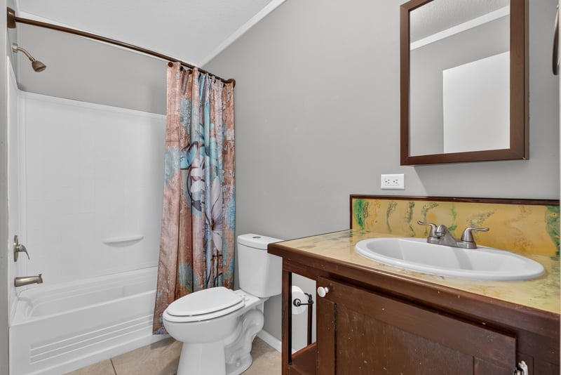 Bathroom with tub, shower curtain and vanity at 2549 Snapdragon Ave, Middleburg, FL 32068