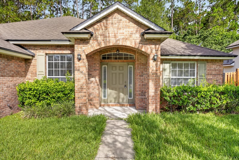 Arched entry with glass door and brick facade at 299 John's Creek Pkwy, St. Augustine, FL 32092