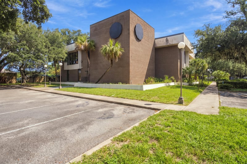 Brick building exterior along sidewalk and parking lot at 101 Scholars Wy