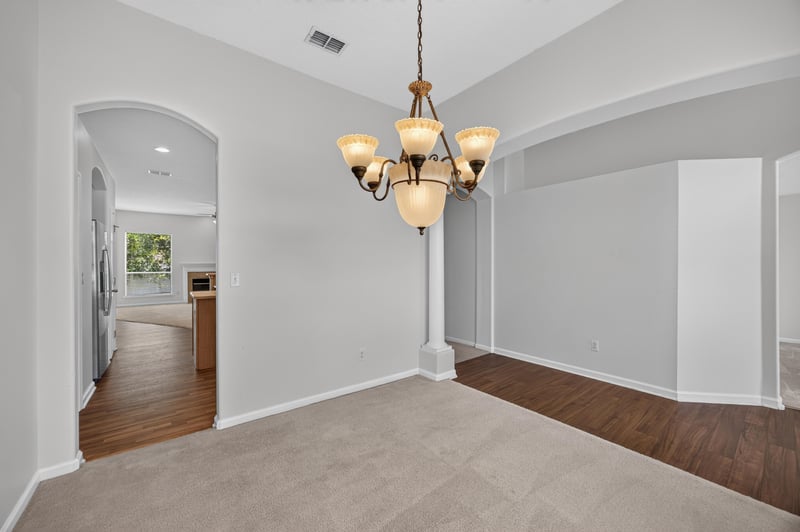Dining room with chandelier and view into kitchen at 2480 Ridge Will Dr, Jacksonville, FL 32246