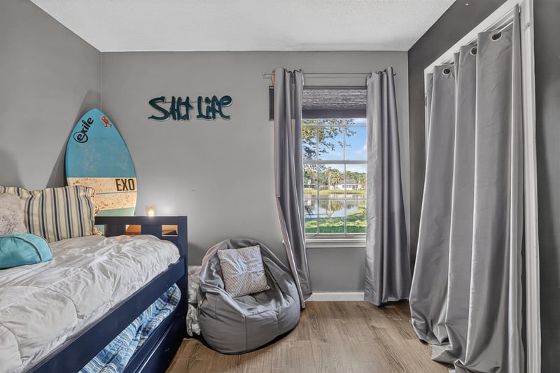 Bedroom with surf-themed sign and bunk bed at 4556 Shaky Leaf Ln N, Jacksonville, FL 32224
