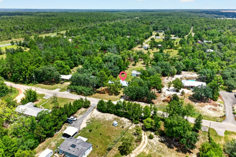 Aerial view of wooded road and distant homes in Keystone Heights, FL