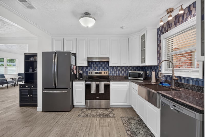 Kitchen with white cabinets and dark countertops at 6059 Karen St, Jacksonville, FL 32244