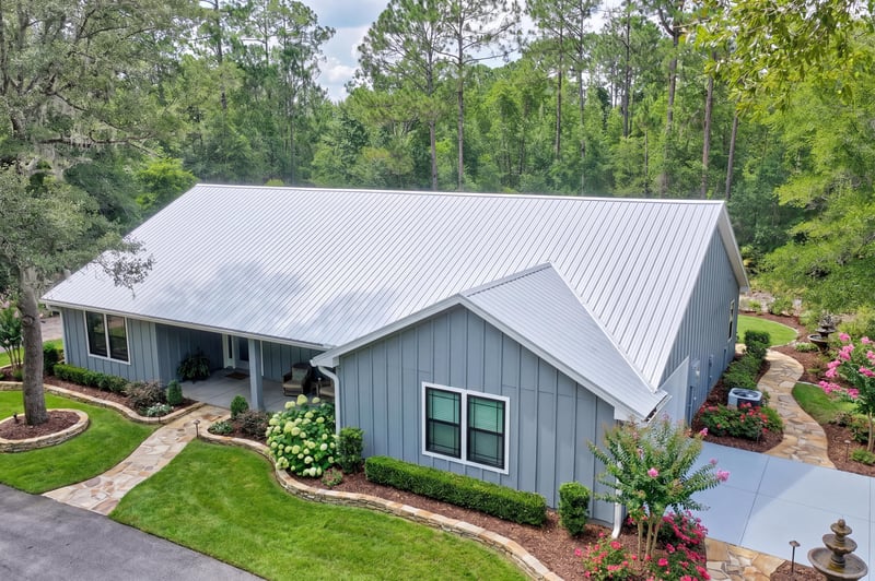 Side exterior view with metal roof and covered porch at 4800 Acacia St, Middleburg, FL 32068