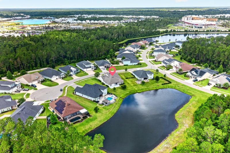 Wide aerial view of neighborhood streets, ponds and rooftops in St. Augustine, FL