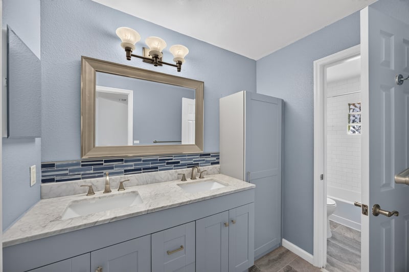 Bathroom with double-sink vanity and framed mirror at 10150 Belle Rive Blvd, Jacksonville, FL