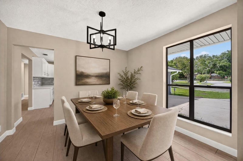 Dining area with virtually staged table and large window at 4117 Wilcrest Ct, Jacksonville, FL 32277