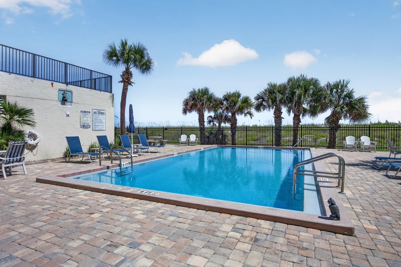 Pool area with building and palm trees at 601 1st St S, Jacksonville Beach