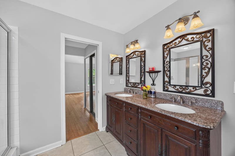 Bathroom with dark wood dual vanity and mirrors at 456 Bay Point Way N, Jacksonville, FL 32259