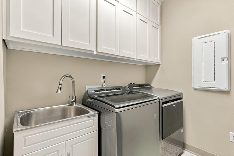 Laundry room with utility sink and side-by-side washer dryer at 3921 Spyglass Hill Ln