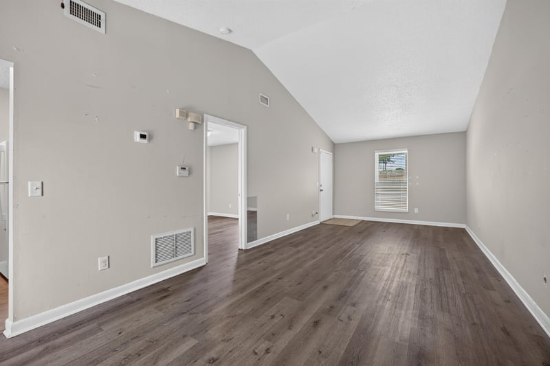 Bedroom with vaulted ceiling and wood-look flooring at 2719 Trollie Ln
