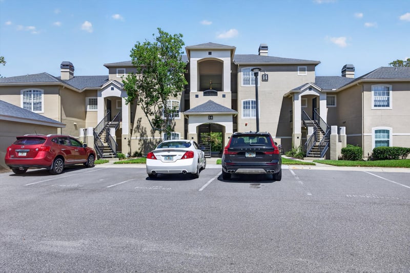Condo building exterior and parking area at 1701 The Greens Way 1415, Jacksonville Beach, FL 32250