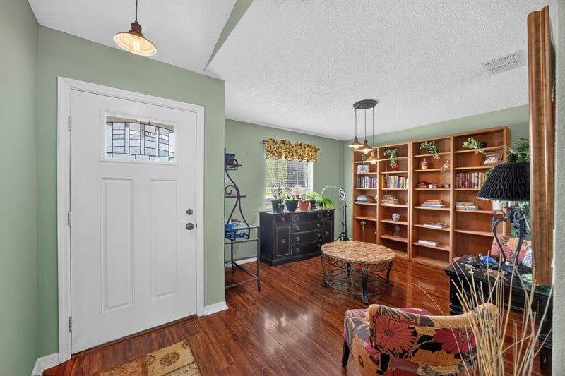 Entry foyer with wood floors and bookshelf at 145 Dover Bluff Dr, Orange Park, FL
