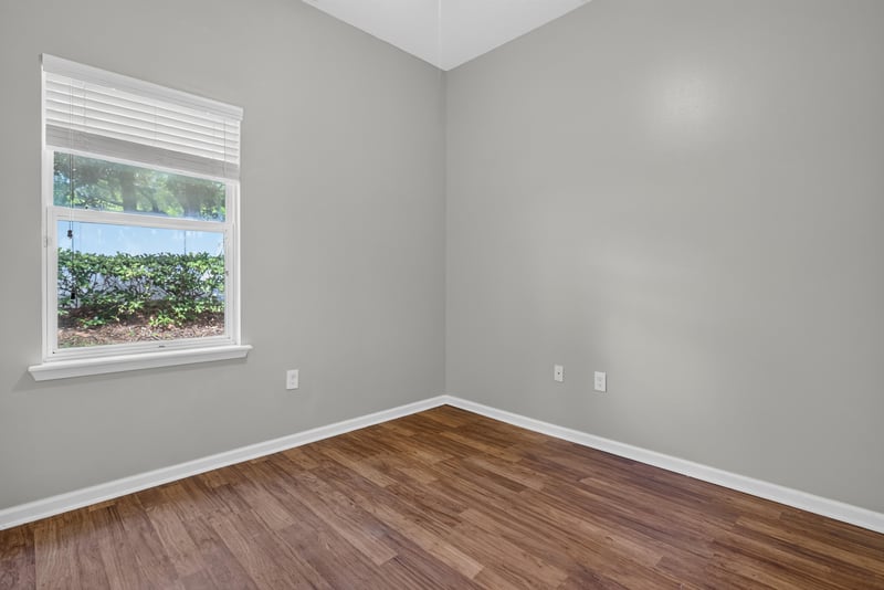 Bedroom with window and wood-look flooring at 8196 Cabin Lake Cir, Jacksonville, FL 32256