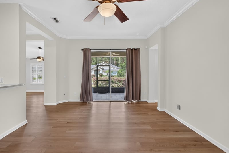 Living room with wood floors and sliding glass doors at 2131 E Stone Creek Dr, Fleming Island, FL