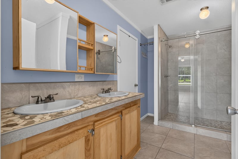 Bathroom vanity with mirror and glass shower at 2549 Snapdragon Ave, Middleburg, FL 32068
