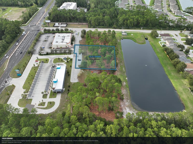 Aerial view of the building, pond, and tree-lined parcel at 4900 US-1, St. Augustine, FL 32086