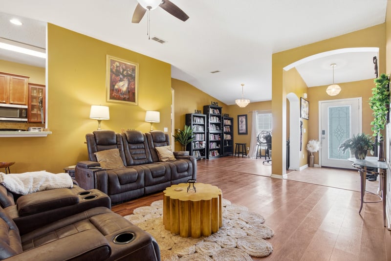 Living room with arched doorway and seating area at 7392 Timber Falls Ct