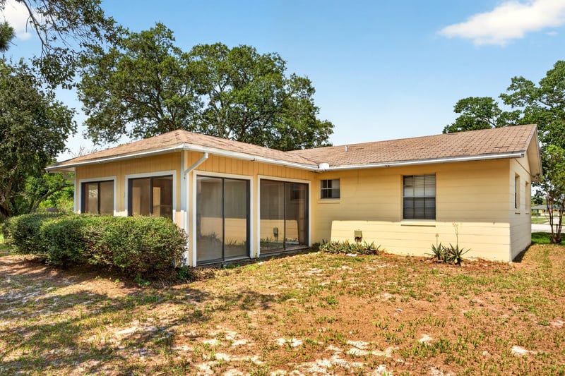 Back exterior view of screened porch and side yard at 328 Palos Ct, St. Augustine, FL