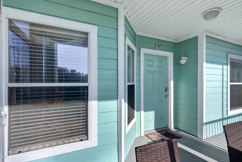 Exterior hallway with teal siding and screened balconies at 206 16th St, St. Augustine, FL 32080
