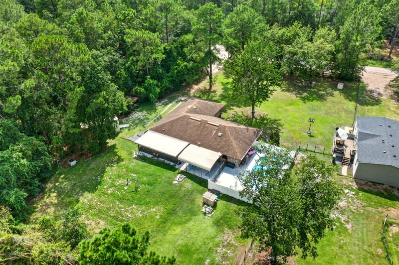 Aerial view of the home with pool amid trees at 2435 Range Line Rd, Middleburg, FL