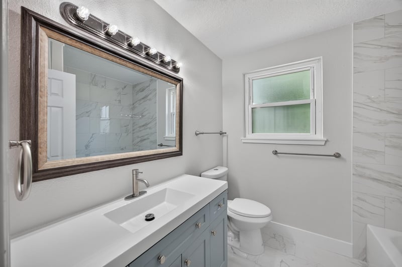 Bathroom vanity with marble-look tile at 6238 Randia Dr, Jacksonville, FL 32210