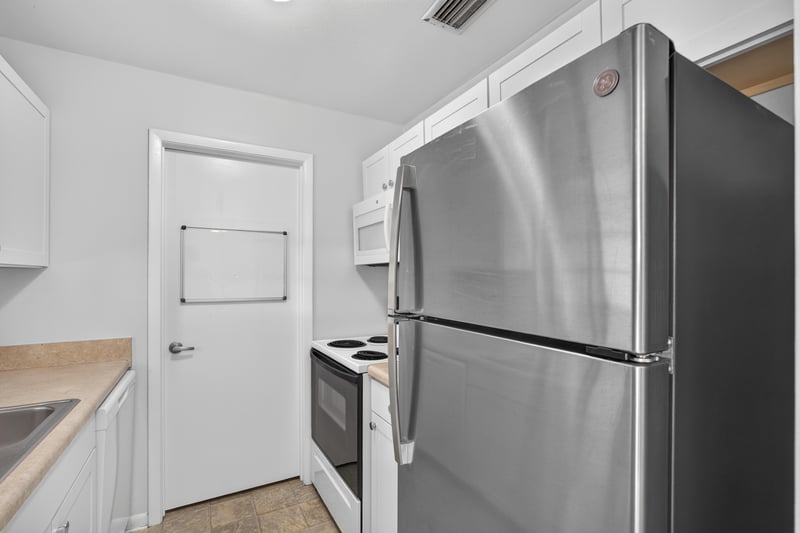Kitchen view with stainless refrigerator and white cabinets at 328 Palos Ct, St. Augustine, FL